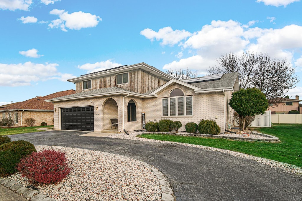 view of front of home with a garage and a front lawn