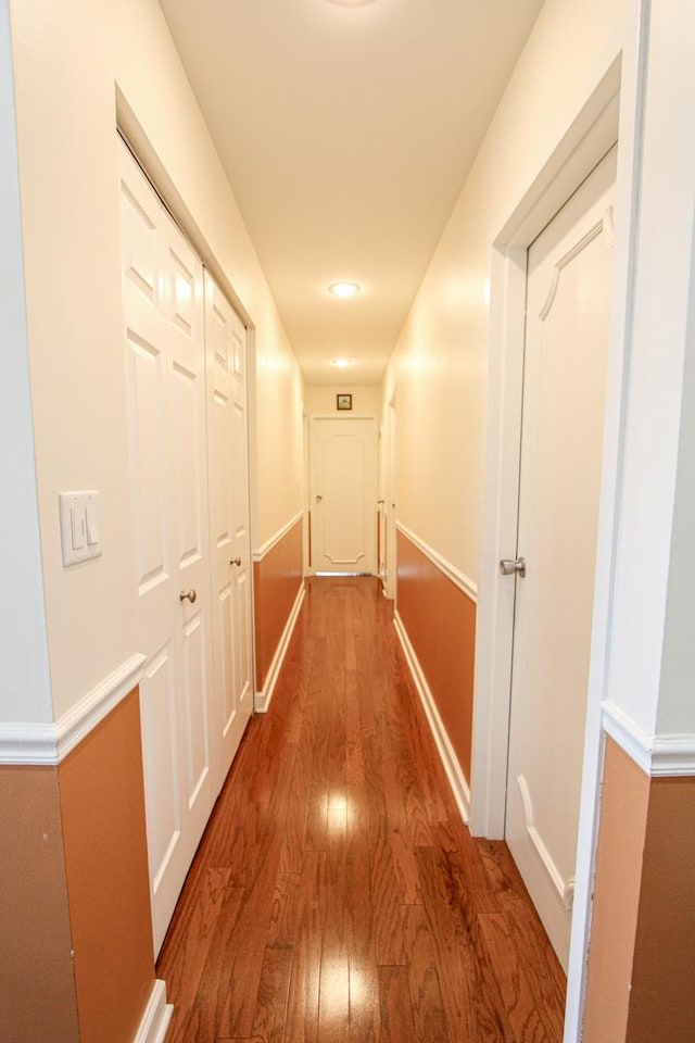 hallway with hardwood / wood-style flooring