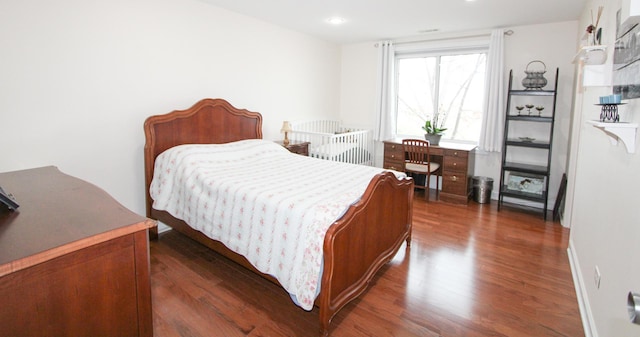 bedroom with dark wood-type flooring