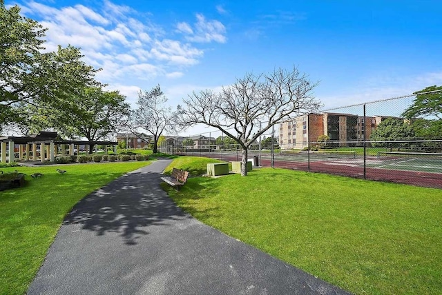 view of community with a yard and tennis court