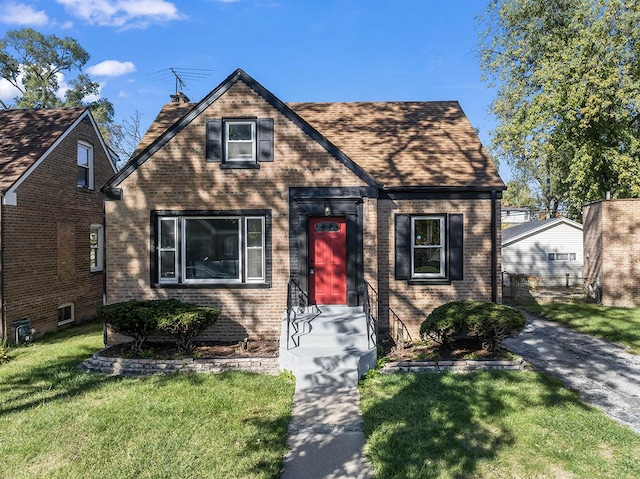 tudor-style house featuring a front yard