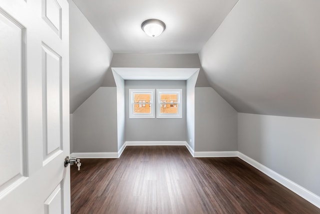 bonus room featuring dark wood-type flooring and vaulted ceiling