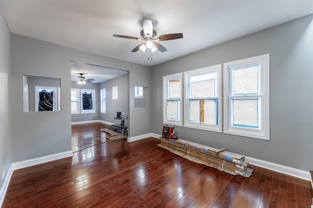 interior space featuring ceiling fan, a healthy amount of sunlight, and dark wood-type flooring