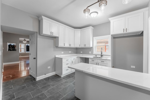 kitchen with white cabinets, ceiling fan, sink, and dark wood-type flooring