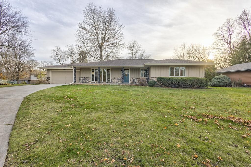 ranch-style house featuring a front lawn and a garage