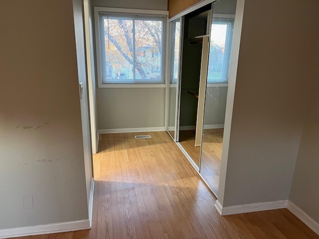 hallway with light hardwood / wood-style floors