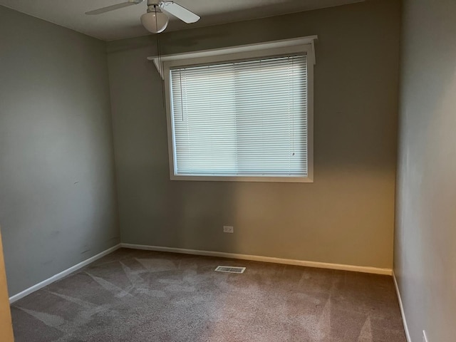 carpeted spare room featuring ceiling fan