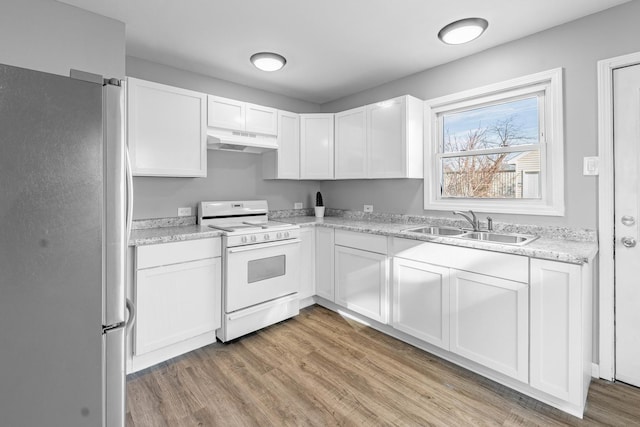 kitchen with white range, sink, light hardwood / wood-style flooring, white cabinets, and stainless steel refrigerator