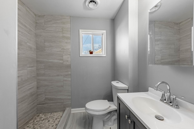 bathroom featuring wood-type flooring, vanity, toilet, and walk in shower