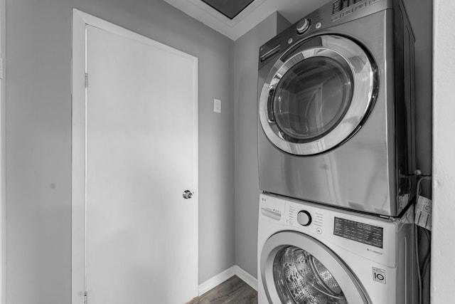 washroom featuring hardwood / wood-style floors, stacked washer / dryer, and ornamental molding