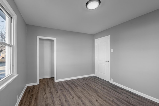 spare room with plenty of natural light and dark hardwood / wood-style flooring