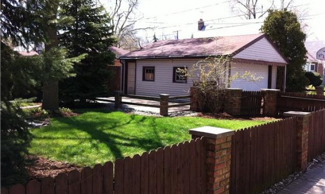 rear view of house with a yard, an outdoor structure, and a garage