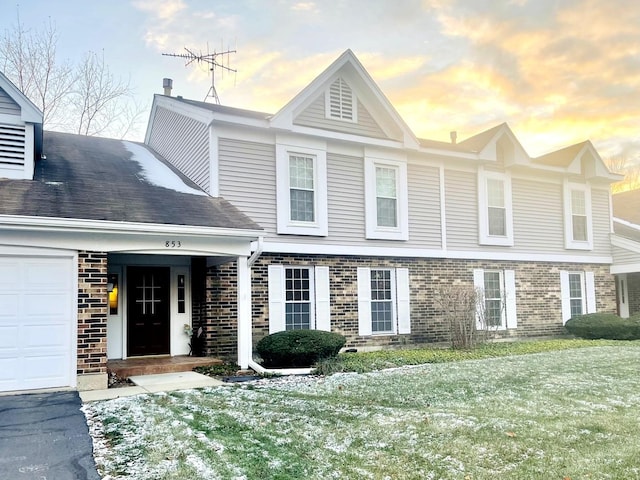 view of front of home with a yard and a garage