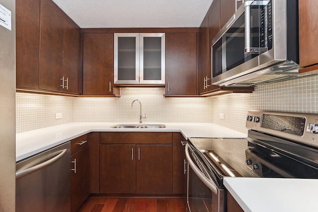 kitchen featuring tasteful backsplash, dark brown cabinets, stainless steel appliances, sink, and dark hardwood / wood-style floors