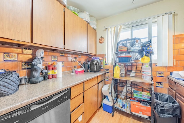 kitchen featuring dishwasher, light wood-type flooring, and backsplash