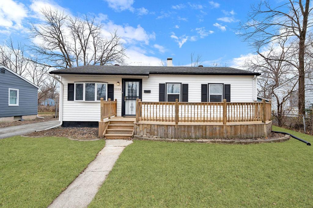 view of front facade with a front lawn and a deck