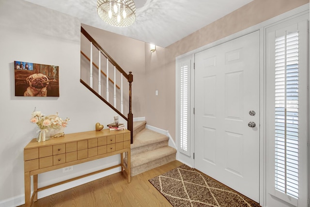 entryway featuring hardwood / wood-style flooring and a chandelier