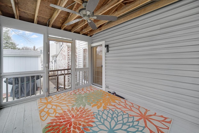 sunroom featuring beamed ceiling and ceiling fan