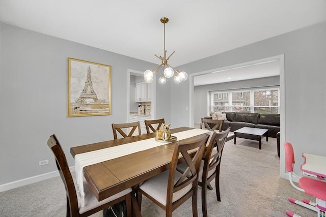 dining area with light carpet and an inviting chandelier