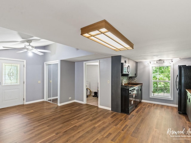 kitchen with ceiling fan, sink, tasteful backsplash, dark hardwood / wood-style flooring, and appliances with stainless steel finishes