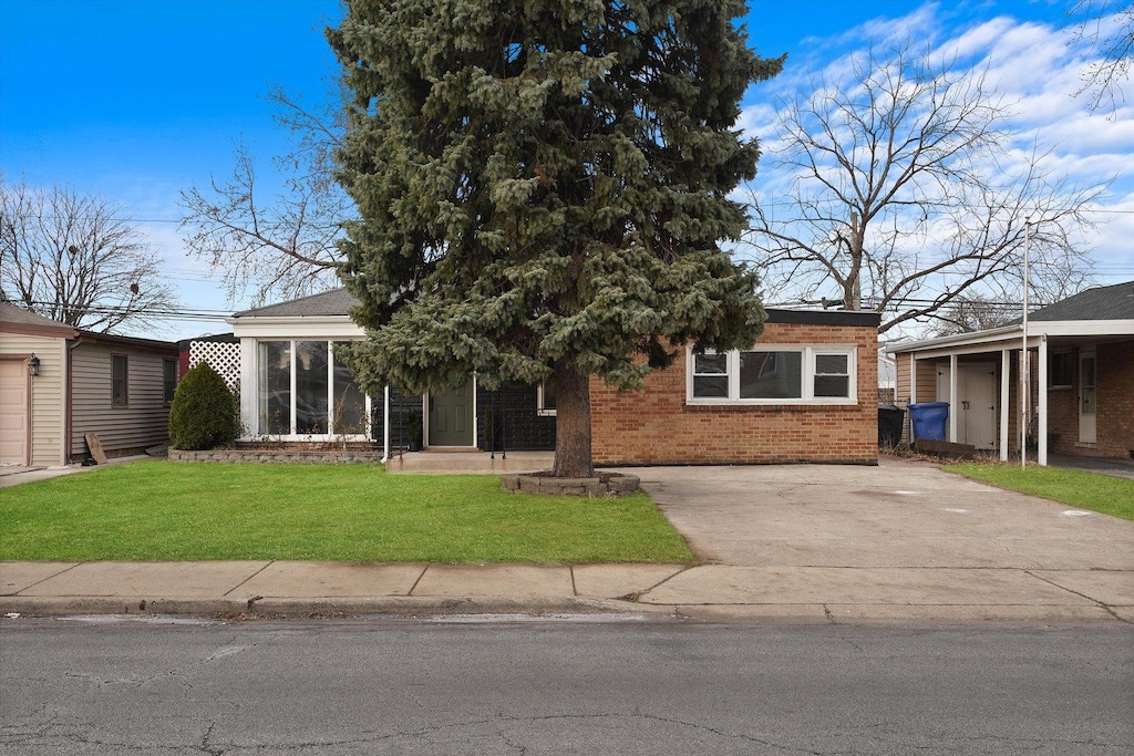 view of front of house featuring a sunroom and a front lawn