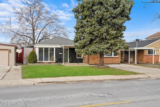 view of front of property with a garage, a front lawn, and an outdoor structure