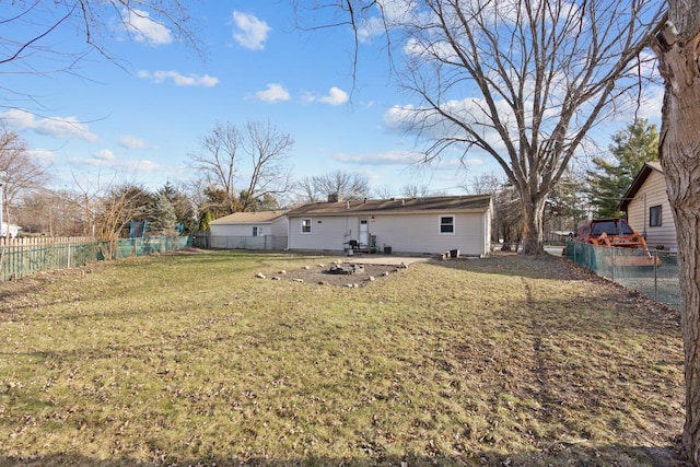 back of property featuring a yard and an outdoor fire pit