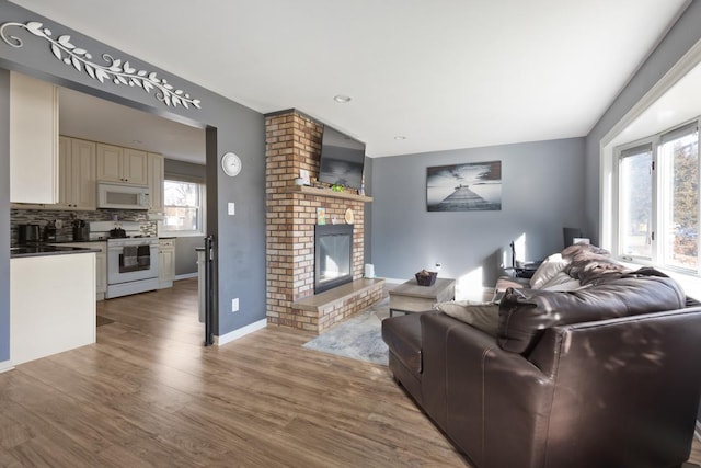 living room with wood-type flooring and a brick fireplace