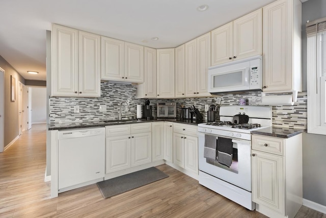 kitchen with white appliances, backsplash, light hardwood / wood-style flooring, and sink