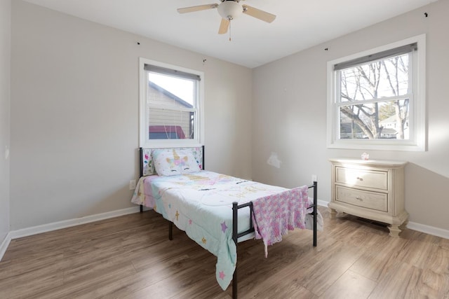 bedroom with multiple windows, ceiling fan, and light hardwood / wood-style floors