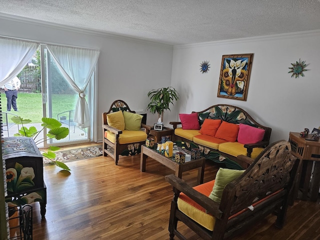 living room featuring wood-type flooring, a textured ceiling, and ornamental molding