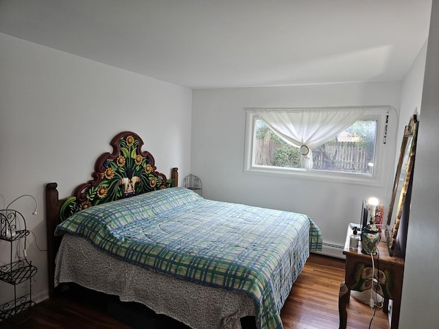 bedroom featuring multiple windows, hardwood / wood-style floors, and a baseboard heating unit