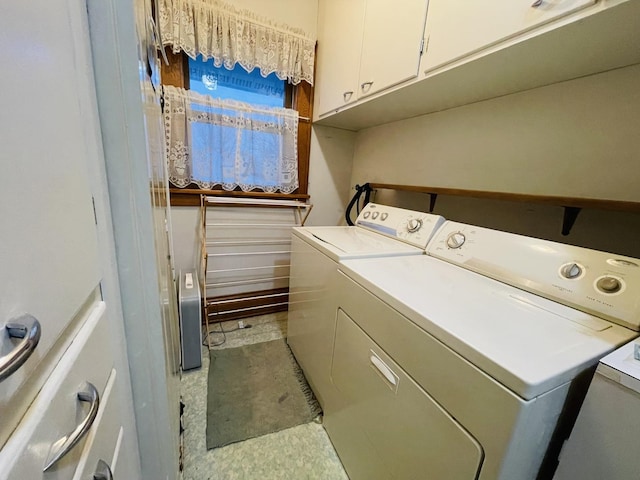 laundry area with washer and clothes dryer and cabinets