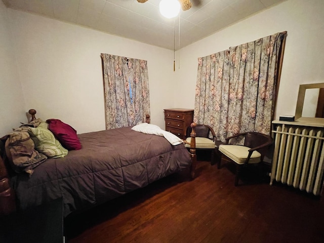 bedroom with radiator, ceiling fan, and dark wood-type flooring