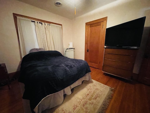 bedroom with dark wood-type flooring