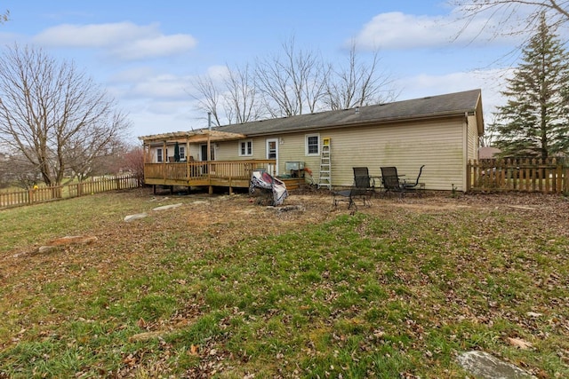 back of house featuring a lawn and a deck