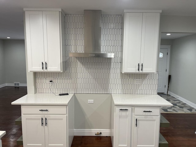 kitchen featuring wall chimney exhaust hood, dark hardwood / wood-style flooring, and white cabinetry