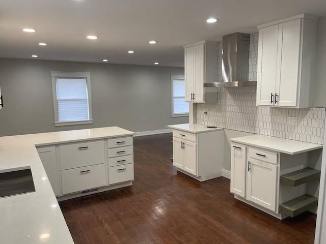 kitchen with white cabinets, dark hardwood / wood-style flooring, and wall chimney range hood