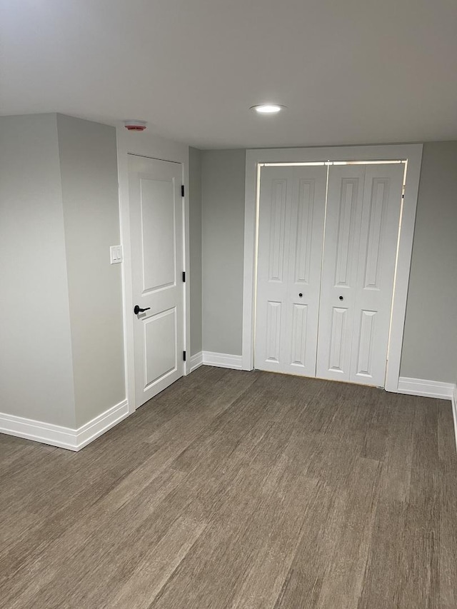 unfurnished bedroom featuring dark hardwood / wood-style flooring and a closet