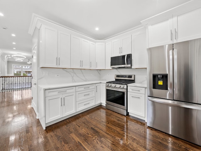 kitchen featuring dark hardwood / wood-style flooring, white cabinetry, backsplash, and appliances with stainless steel finishes