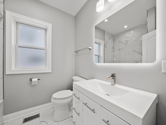 bathroom featuring a tile shower, vanity, and toilet