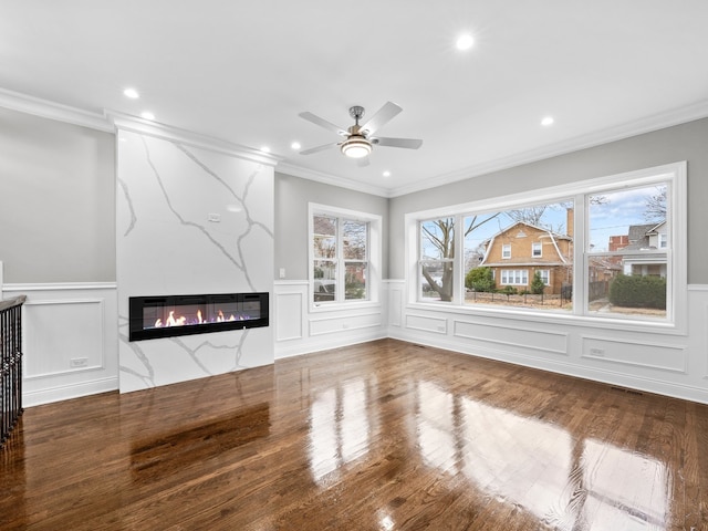 unfurnished living room with crown molding, a high end fireplace, and wood-type flooring