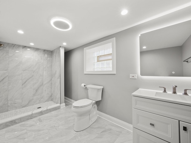 bathroom featuring vanity, toilet, and tiled shower