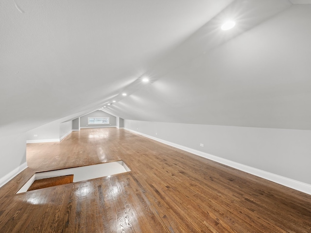 additional living space featuring hardwood / wood-style flooring and vaulted ceiling