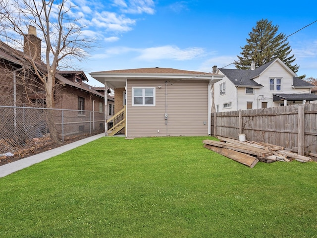 rear view of property with a lawn