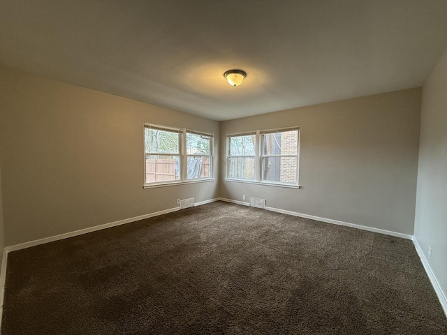 unfurnished room featuring dark carpet