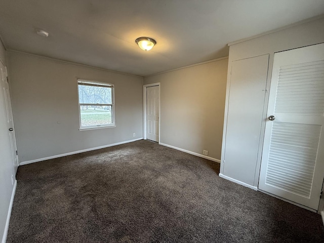 unfurnished bedroom featuring crown molding and dark colored carpet