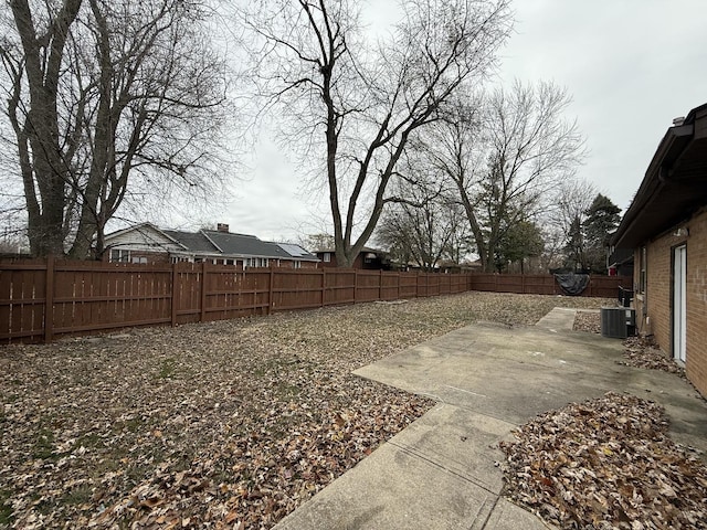 view of yard with central air condition unit and a patio