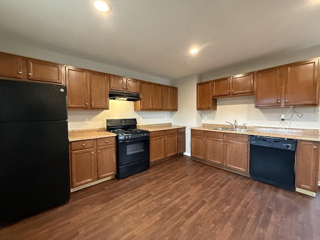 kitchen featuring black appliances, dark hardwood / wood-style floors, and sink