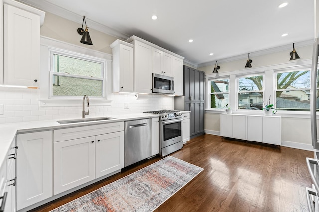 kitchen with decorative backsplash, appliances with stainless steel finishes, sink, and white cabinetry